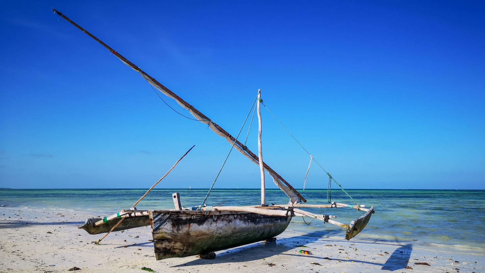 A dhow sitting on the beach in front of the Two Villa Hotel for Sale in Jambiani, Zanzibar by Tanganyika Estate Agents